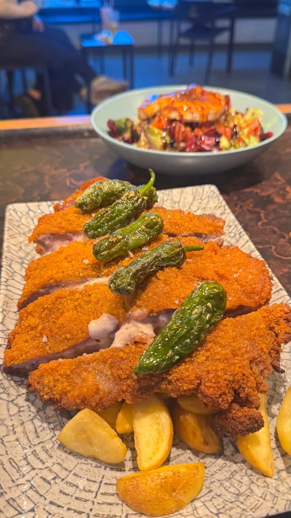 Cachopo tradicional de ternera con pimientos de padrón y patatas