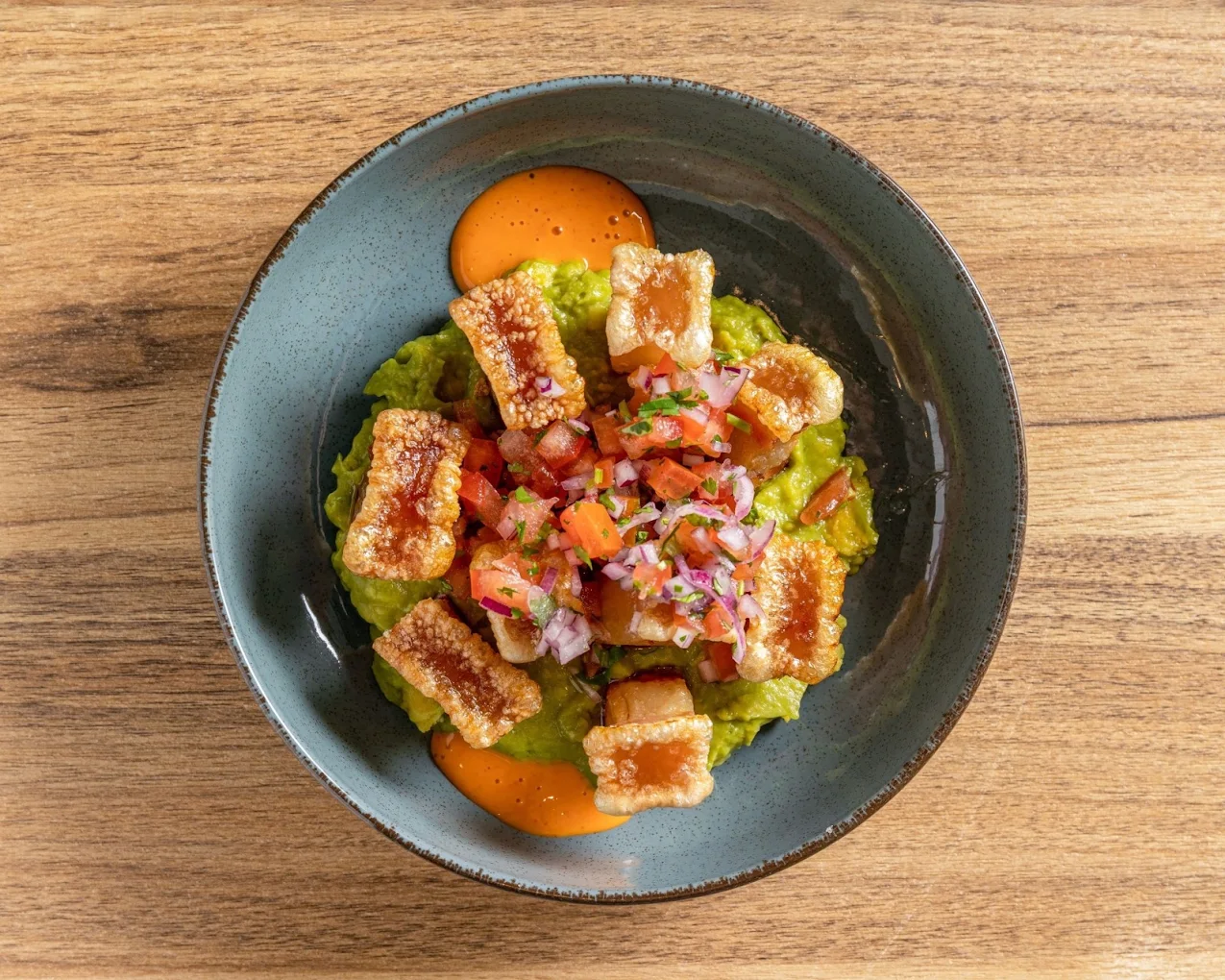Torreznos crujientes sobre guacamole con pico de gallo